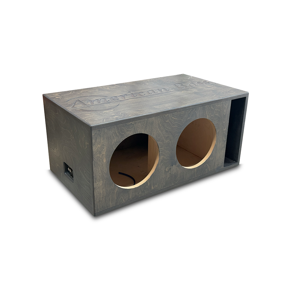 Featuring a rectangular wooden design with two circular cutouts on the front and "American Bass" engraved on the top, the Basshead Supply American Bass Dual 15" King Ported Enclosure is a premium custom subwoofer box, displayed against a white background.