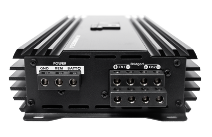 Close-up of the VFL Audio Hybrid 275.4 Class D High Performance Multichannel Amplifier's rear panel, showing labeled power and speaker terminals (GND, REM, BATT, Ch1, Ch2, Bridged) and side heat sink fins. Brand: VFL.
