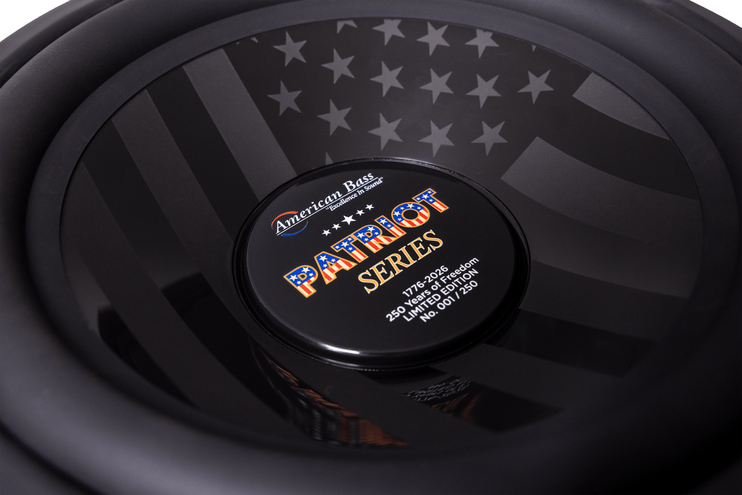 Close-up of the American Bass Patriot Series Limited 250 Edition Subwoofer, showcasing its black and gray American flag design, labeled 250 watts, 4 ohm, and individually numbered as #61 of only 120 produced.